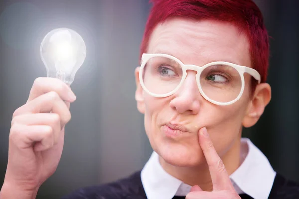 Portrait of woman holding a glowing lightbulb — Stock Photo, Image