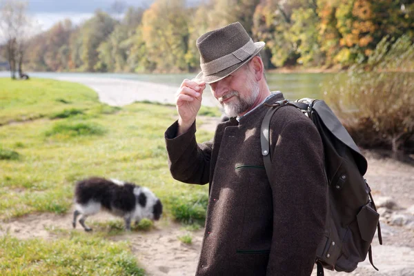Bavarian man by the river with his dog — Stock Photo, Image