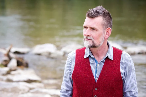 Portret van de mens in zijn 50s permanent door de rivier — Stockfoto