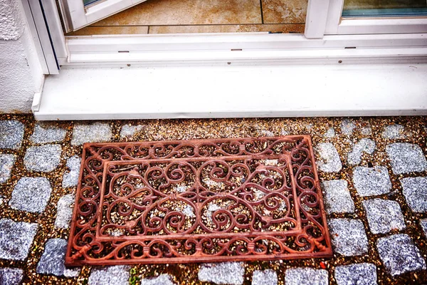 Iron doormat in front of entrance — Stock Photo, Image