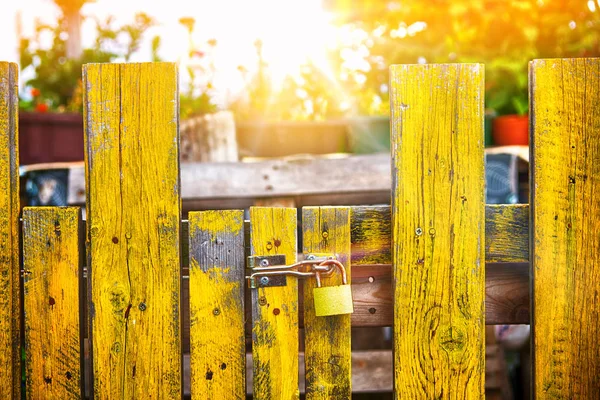 Vieille clôture en bois jaune avec une serrure — Photo