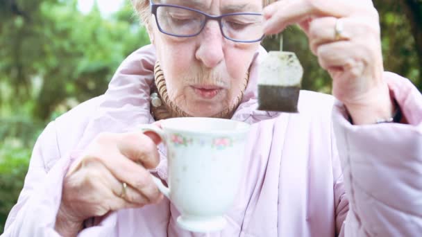 Cinemagraph Older Woman Holding Teabag Cup — Stock Video