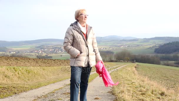 Cinemagraph Van Oudere Vrouw Stond Buiten Velden Bedrijf Een Sjaal — Stockvideo