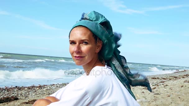 Cinemagraph Hermosa Mujer Con Pañuelo Cabeza Sentado Playa — Vídeo de stock