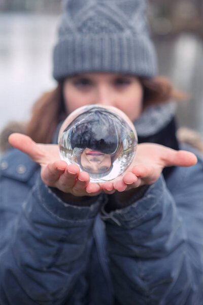 closeup of young woman holding a glass sphere