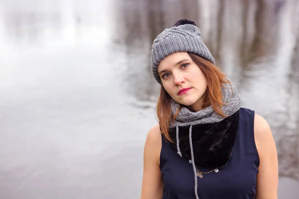 Young woman standing by the water in the cold — Stock Photo, Image