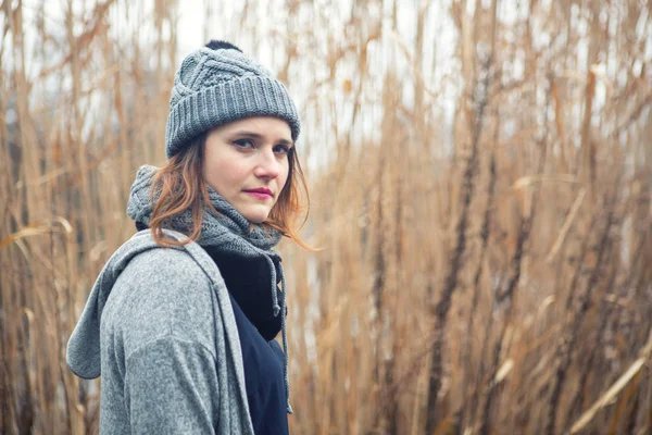 Portrait of young woman outdoors with reeds in the background — Stock Photo, Image