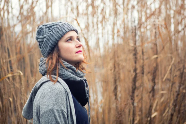 Portret van de jonge vrouw buitenshuis met riet op de achtergrond — Stockfoto