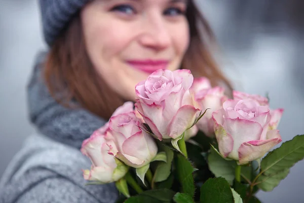 Jeune femme en plein air avec bouquet de roses roses — Photo