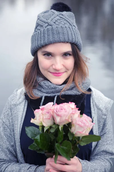 Young woman outdoors with bouquet of pink roses — Stock Photo, Image