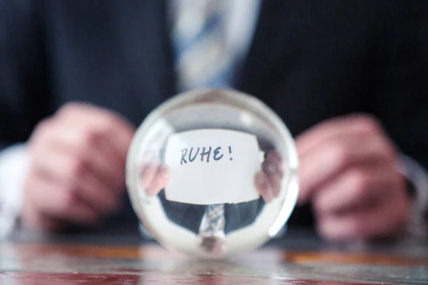 Mann hält Papier mit deutschem Wort für Ruhe vor Glas — Stockfoto