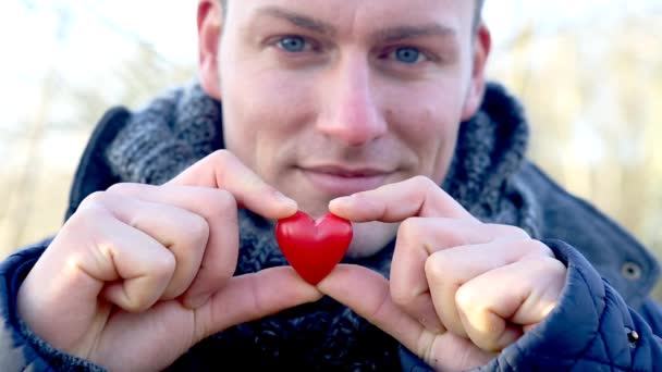 Cinemagraph Handsome Man Holding Small Blinking Heart — Stock Video