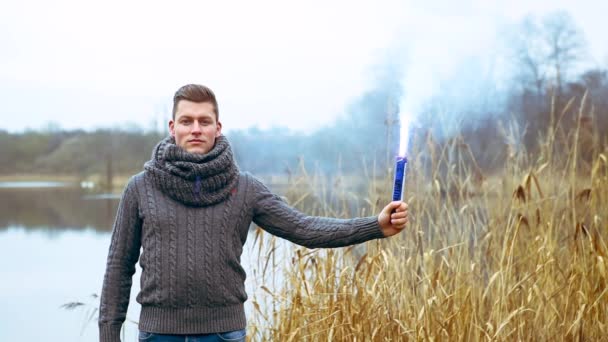 Кинематограф Красивого Мужчины Перед Озером Дымящимся Факелом — стоковое видео