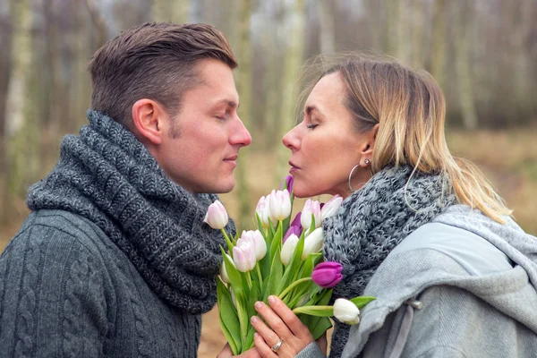 Pareja al aire libre con flores abrazándose —  Fotos de Stock