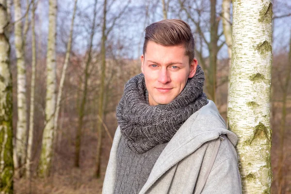 Handsome blond man in forest in the cold — Stock Photo, Image