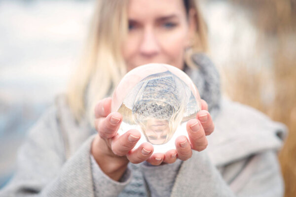 blond woman holding up a glass ball