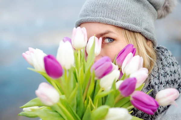 Mujer escondida detrás de un ramo de tulipanes — Foto de Stock