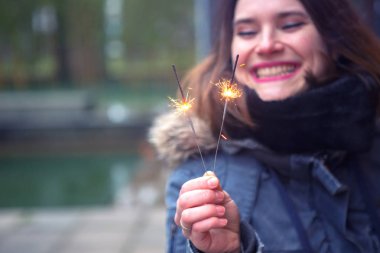 havai fişekleri açık havada tutan genç kadın portresi