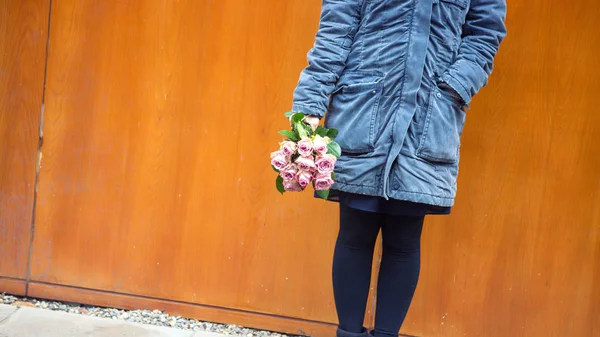Young woman standing outside with bouquet of roses — Stock Photo, Image