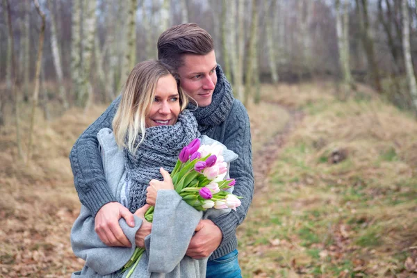 Paar im Freien mit Blumen, die sich umarmen — Stockfoto