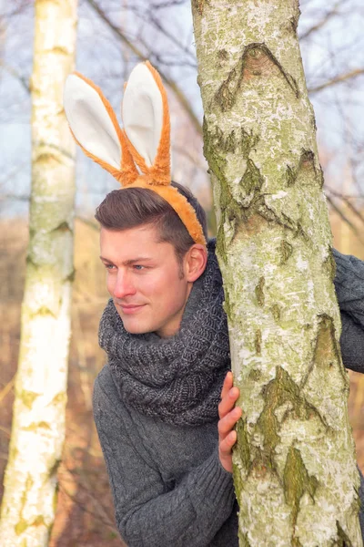Yakışıklı sarışın adam parkta tavşan kulakları ile — Stok fotoğraf