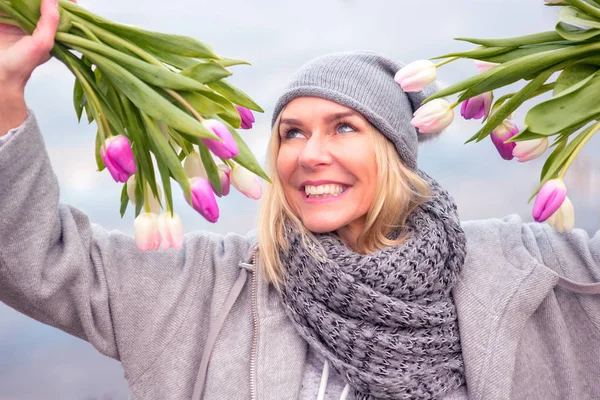 Hermosa mujer rubia al aire libre con tulipanes — Foto de Stock