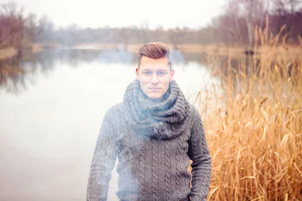 Handsome man in front of lake surrounded by fog — Stock Photo, Image