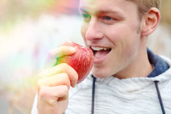 Красавчик, поедающий красное яблоко — стоковое фото