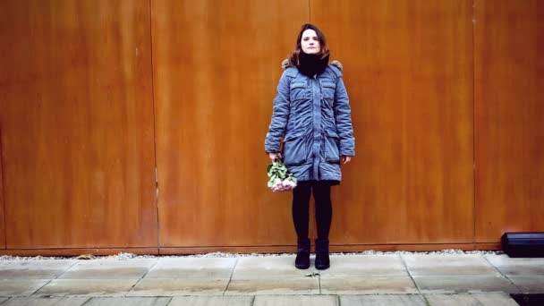 バラの花束と木製の壁に立っている若い女性の Cinemagraph — ストック動画