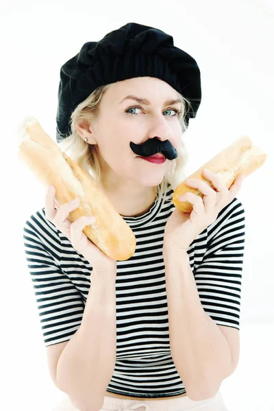 Mujer vestida como un hombre francés con bigote sosteniendo una baguette — Foto de Stock