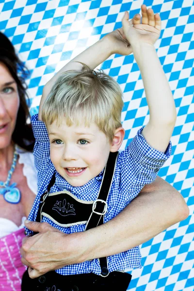 Niño bavariano con madre sobre fondo azul y blanco — Foto de Stock