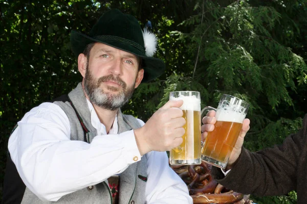 Баварский человек пьет пиво в пивном саду — стоковое фото