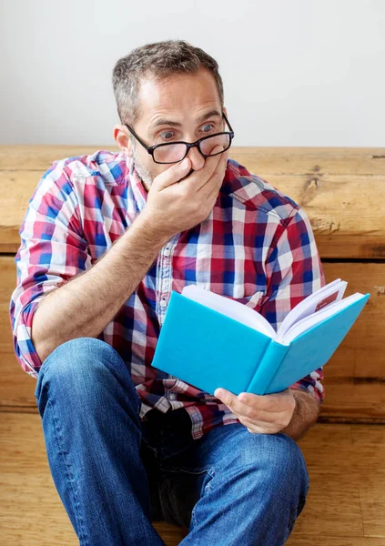 Knappe bebaarde man lezen van een boek — Stockfoto