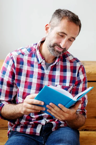 Knappe bebaarde man lezen van een boek — Stockfoto