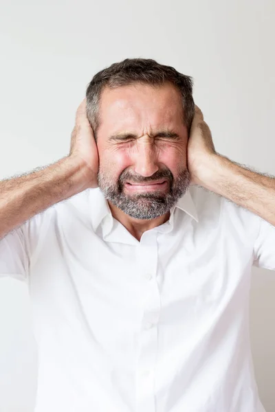 Hombre guapo cubriendo sus oídos de dolor — Foto de Stock