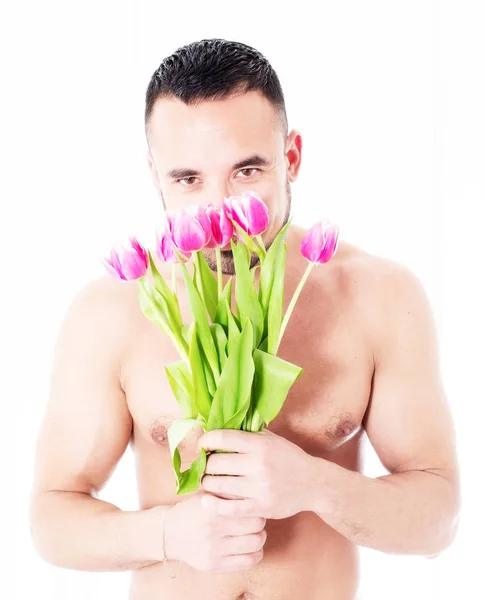 Man with naked upper body holding bunch of tulips — Stock Photo, Image