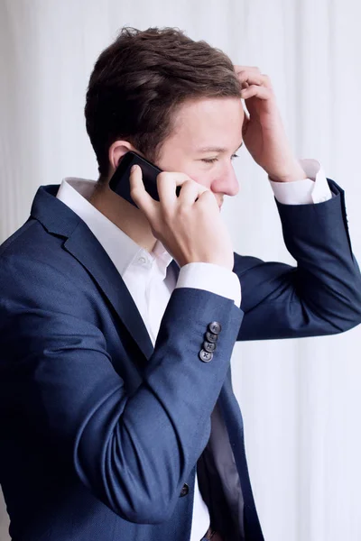 Jeune homme en costume parlant au téléphone — Photo