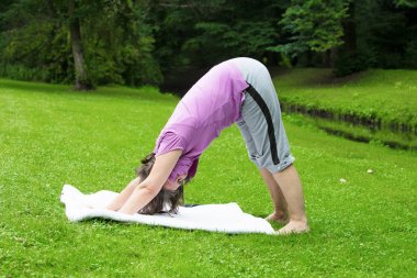 kadın bir parkta yoga yaparken onun 50s
