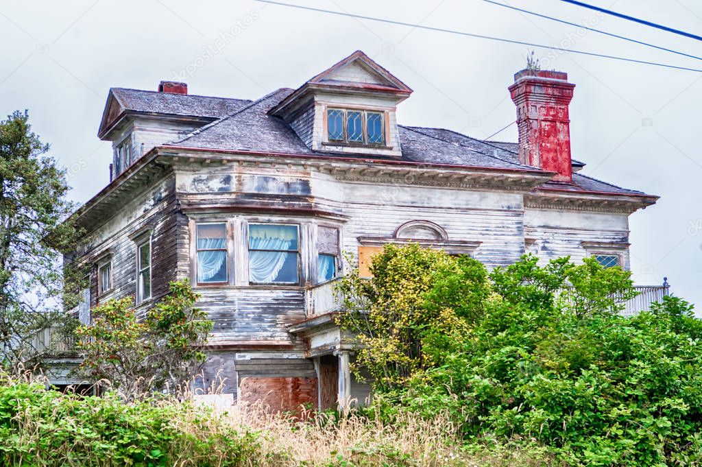 abandoned farm house with overgrown bushes