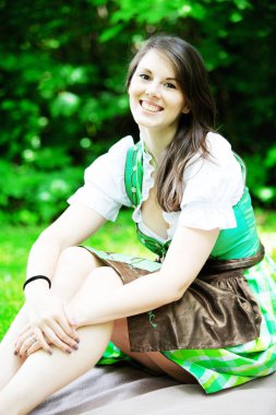 genç kadın üzerinde park battaniyeye oturmuş dirndl