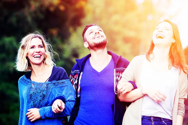 Dos mujeres y un hombre joven caminando y disfrutando del sol —  Fotos de Stock