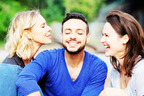 Dos mujeres besándose hombre guapo en sus mejillas —  Fotos de Stock