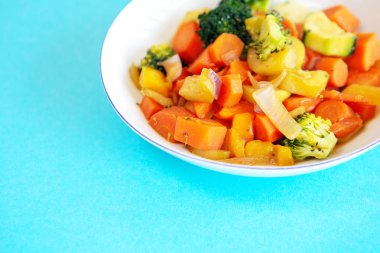 Mavi masada karışık sebze ile beyaz plaka