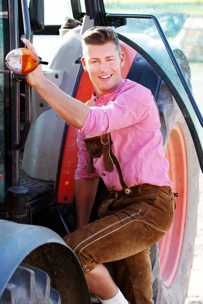 Sarışın Bavyera adam bir traktör tarafından ayakta — Stok fotoğraf