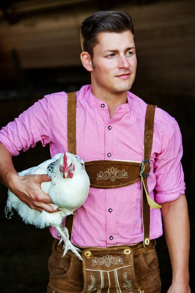 白鶏を保持しているバイエルン若者 — ストック写真