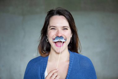 onun yüzüne sahte bıyık tutan genç kadın