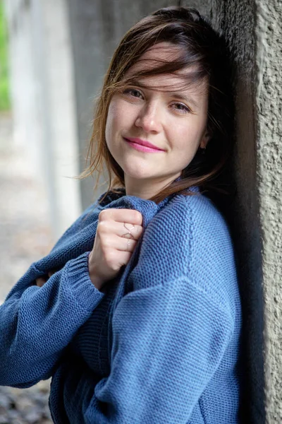 Lachende brunette jonge vrouw in blauwe trui — Stockfoto