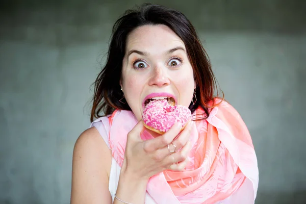 Jovem morena mulher comer um donut — Fotografia de Stock