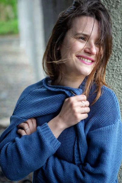 Jeune femme brune souriante en pull bleu — Photo