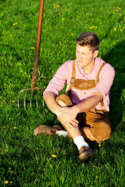 otların arasında oturan sarışın Bavyera adam